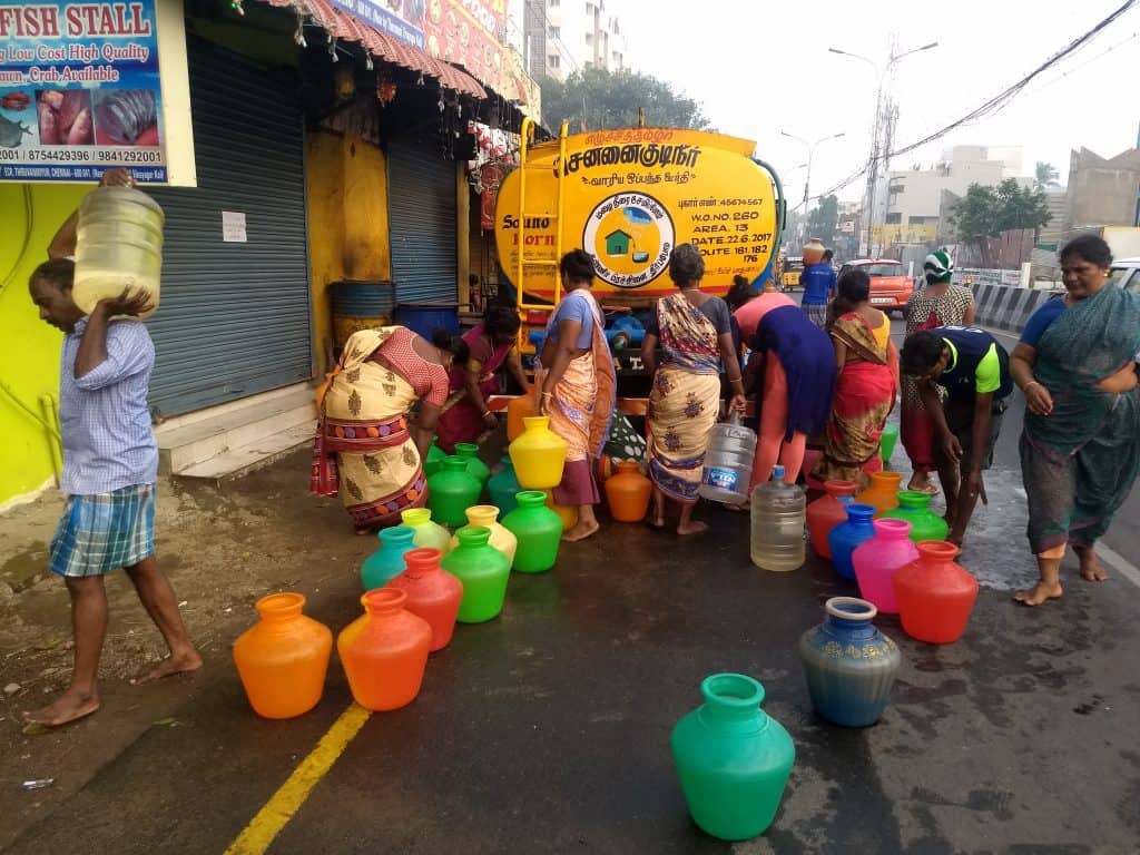 People gather to fill water from the tankers at ECR