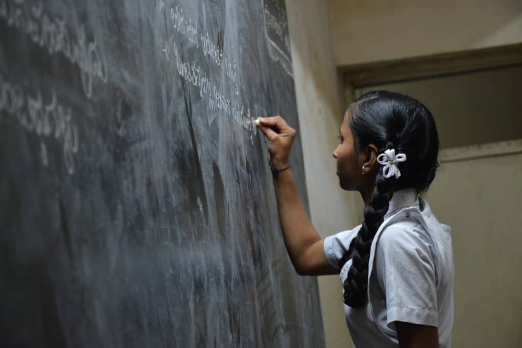 Schoolgirl in front of a blackboard