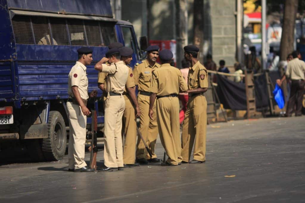 group of policemen gather at a road in colaba