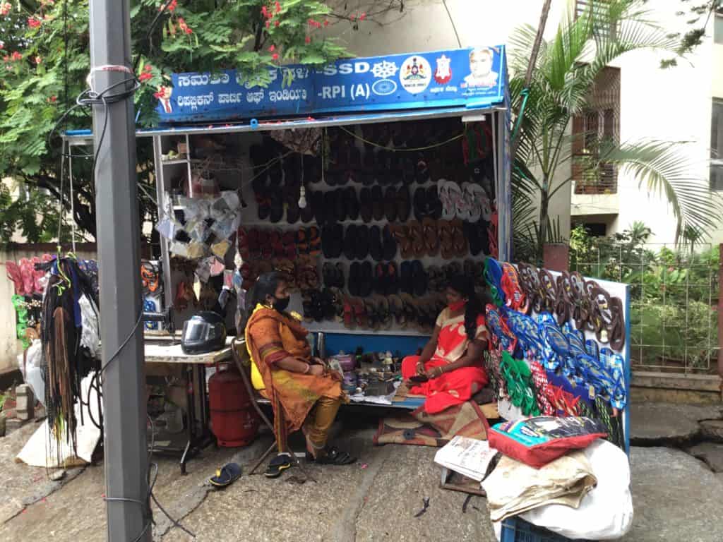 Woman repair cobbler at her workspace on the footpath 