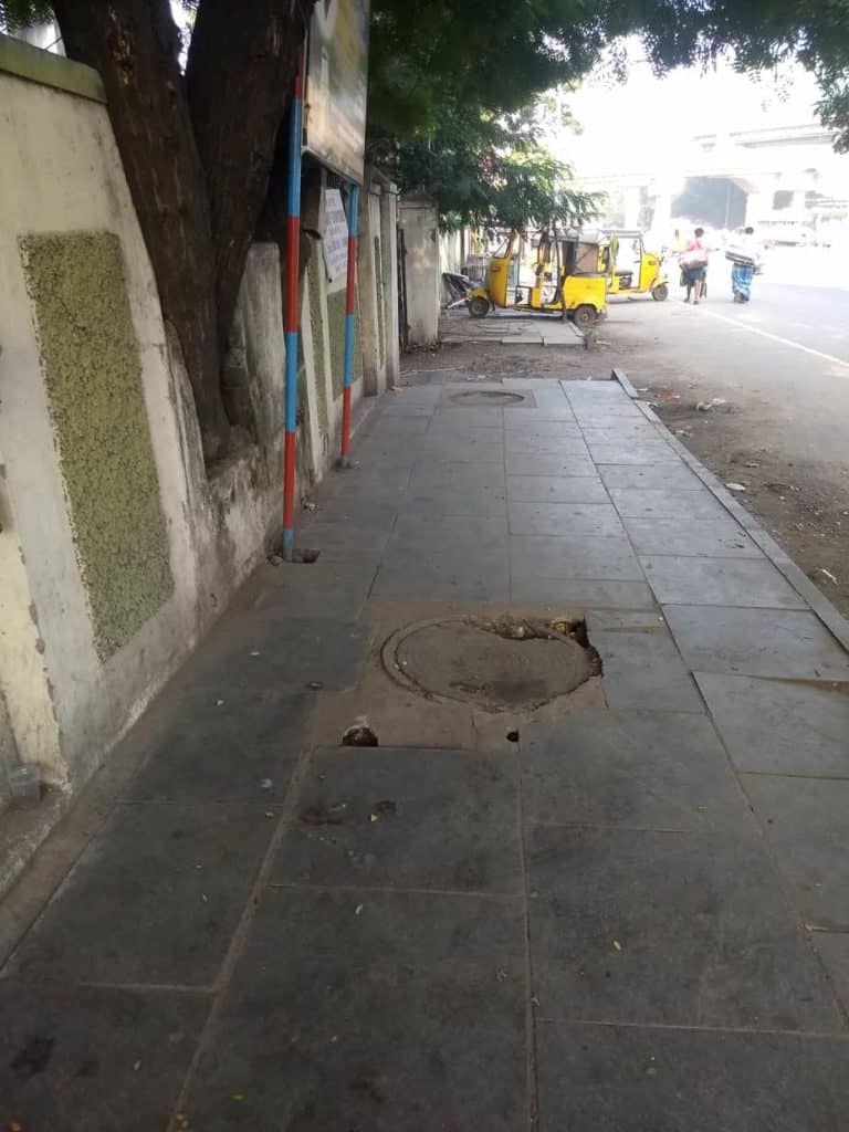 A badly finished manhole sinks on a footpath