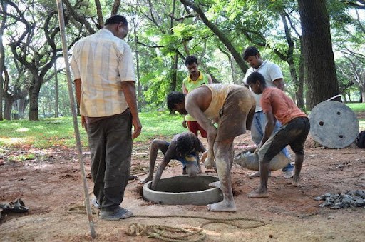Mannuvaddars adding the finishing touches to a well in Cubbon Park.