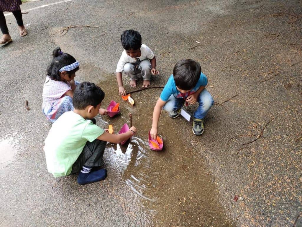 Happier times: preschool kids discover the joy of floating paper boats in a puddle. Pic courtesy: Jyotsna Arun.