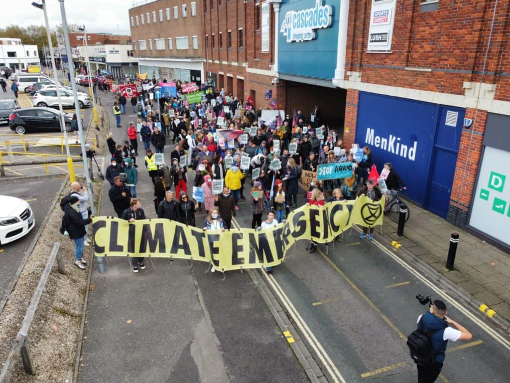 Group of people hold a banner that says 'climate emergency' as they protest outside the COP26 summit in Glasgow