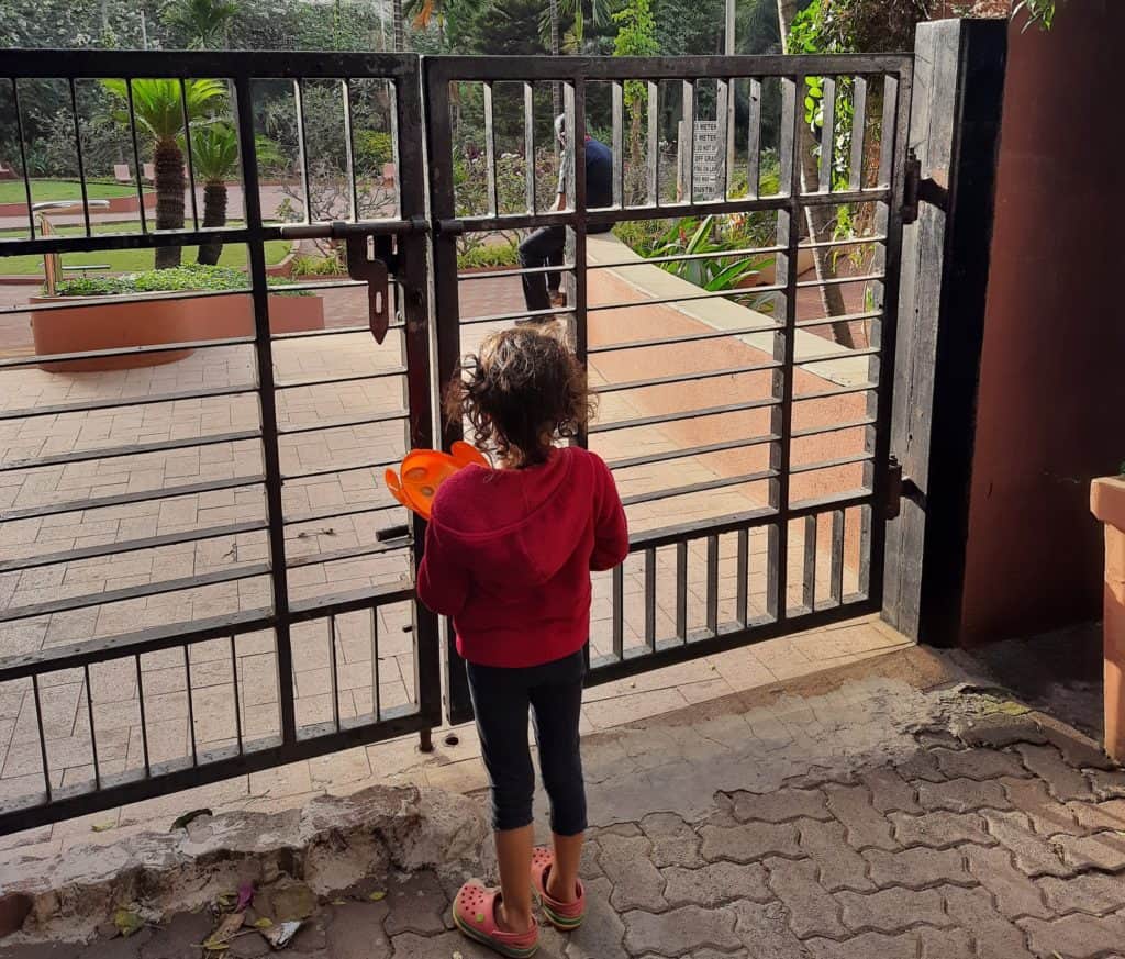 girl waits outside a park gate in Mumbai 