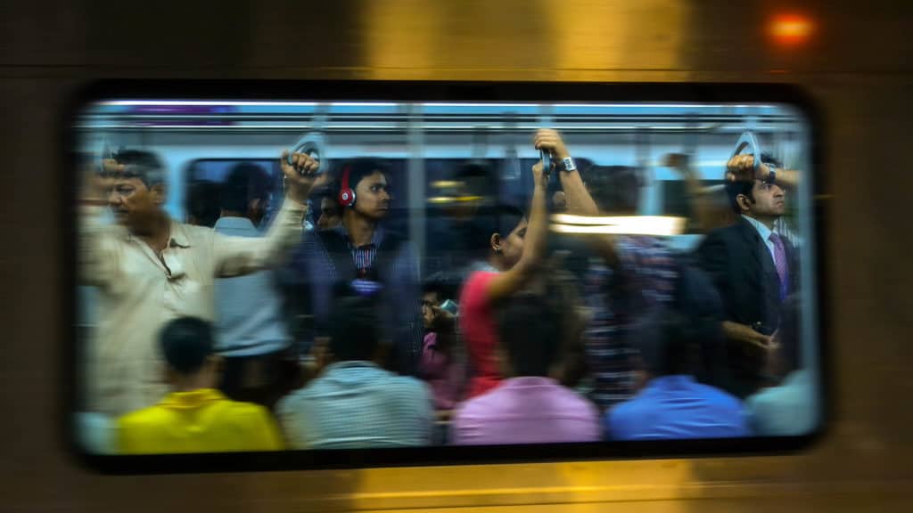 a metro window in Mumbai with passengers 