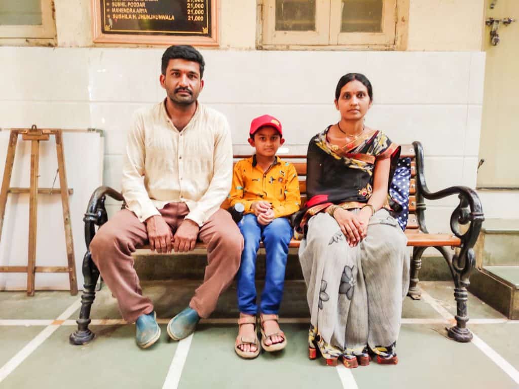 The Borse family poses for a photo on a bench in the Ghadge Maharaj Dharamshala.
