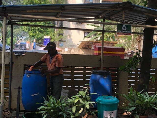 an employee treating the compost in Surabhi building.