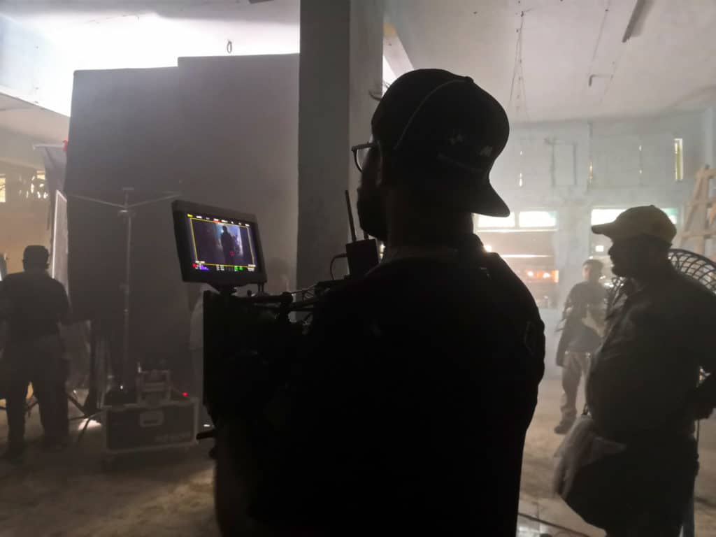 The backlit silhouette of a DOP on a film set 