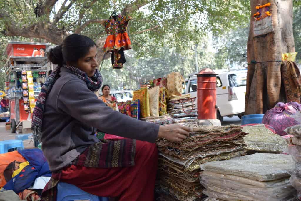 A woman sells occasion wear on the footpath