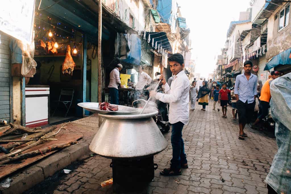 A larger pot on a stove in the middle of a narrow street