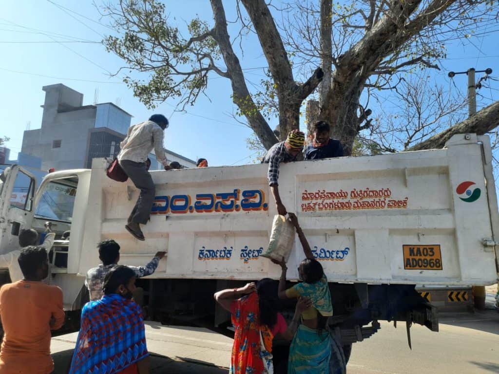 Construction workers boarding a truck at a labour stand