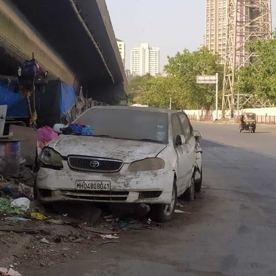 an abandoned vehicle on a road in mumbai