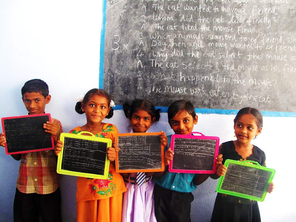 young students holding up chalk boards