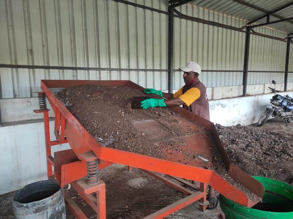 worker sieving the compost