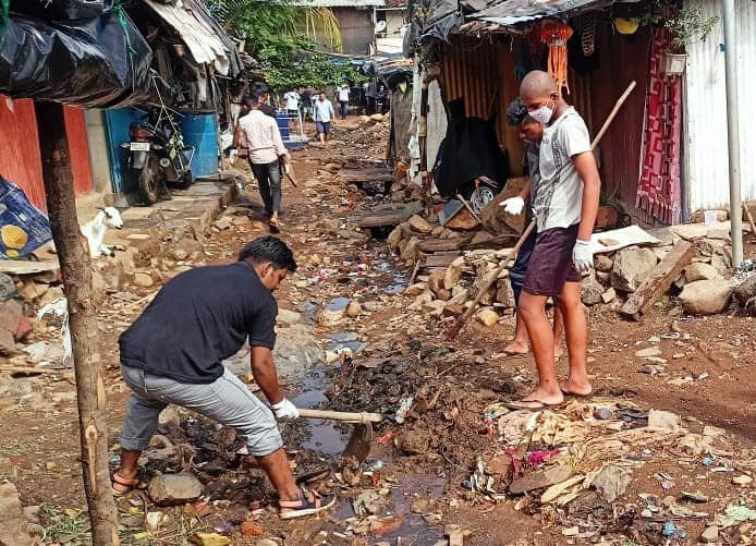 2 people digging a tough in a between a galli in the Kranti Nagar slum, to let water flow straight to the gutter and prevent waterlogging