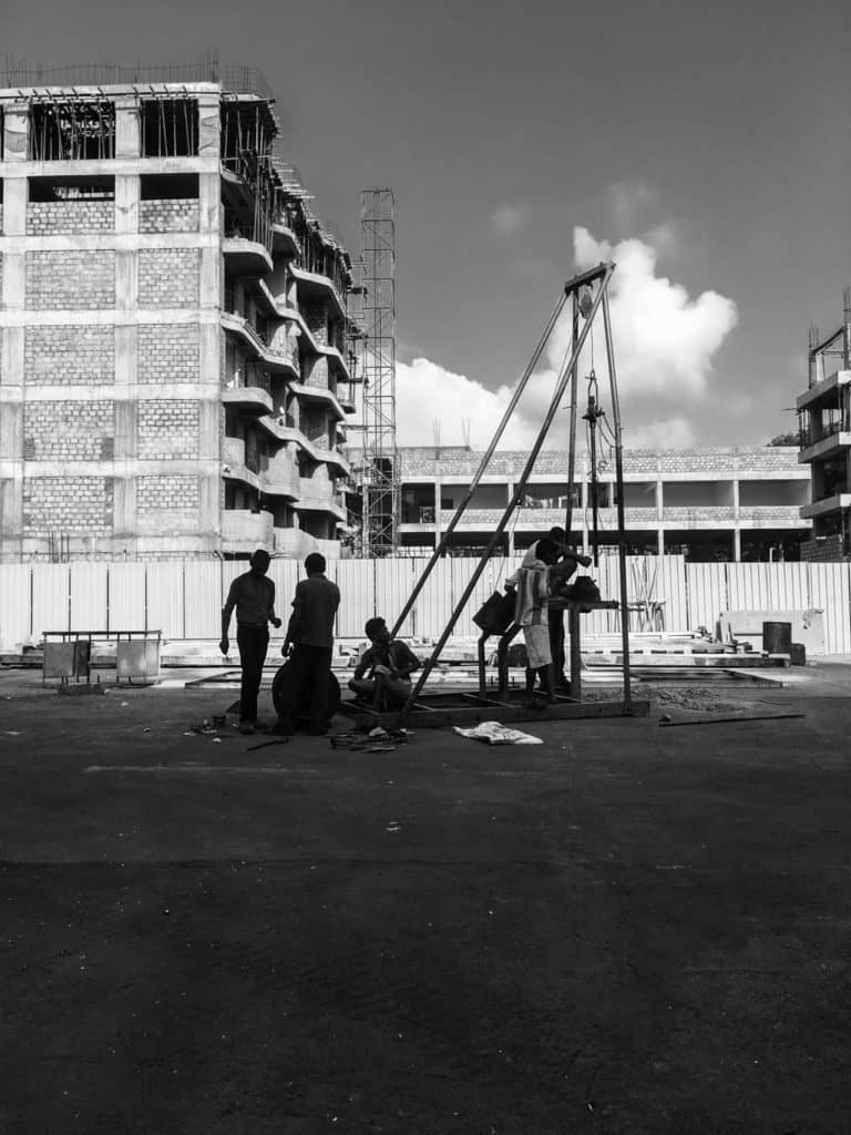 construction workers at work on a construction site by a fire station in mumbai