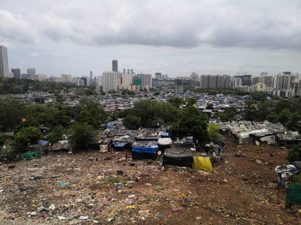 View of slums in front of high rise buildings at the steps of the Sanjay Gandhi National Park