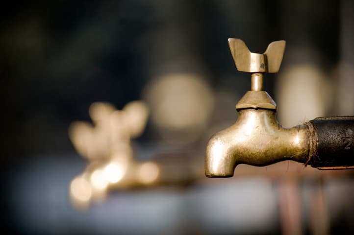 one Brass water tap in focus and two more blurred in the background