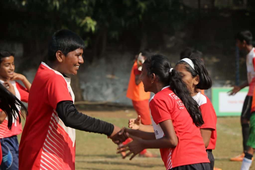 boy shaking hands with a girl on a sports field.