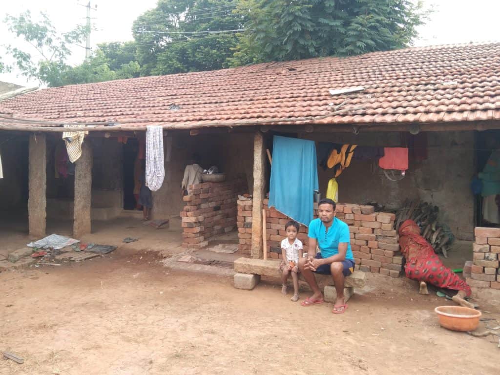 man with child in a village house