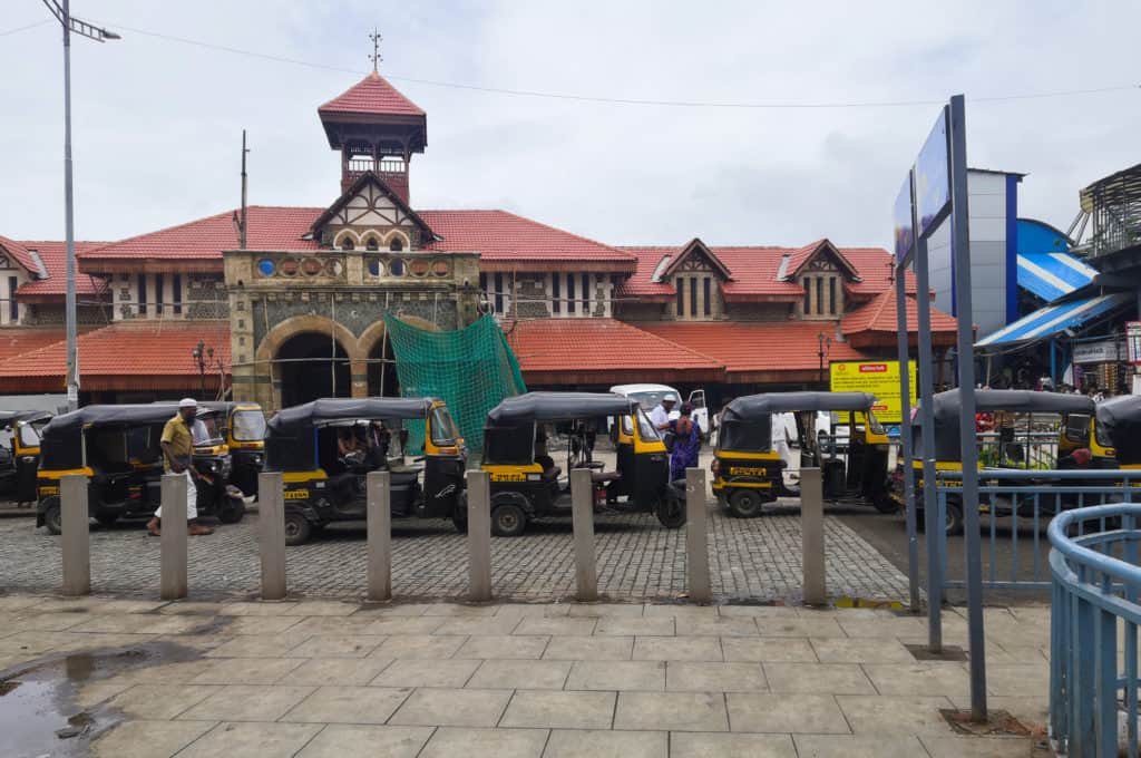 A line of rickshaws in front of the Bandra West station building awaiting passengers
