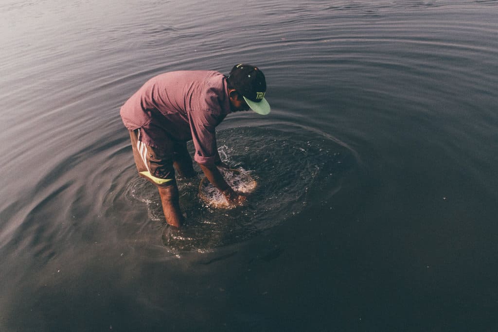 a fisherman in Mumbai catches fish by hand in the sea