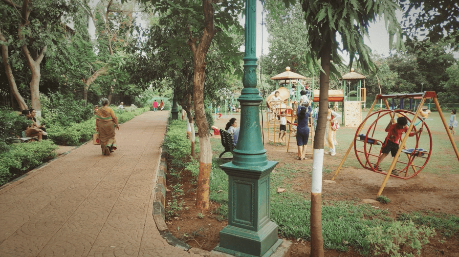 a park in mumbai where children are playing and adults are walking
