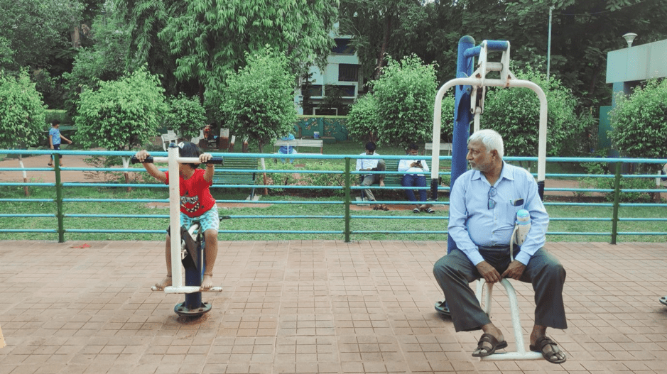 a child and his grandfather play at a park in mumbai