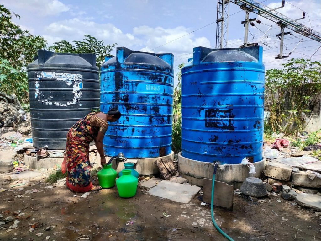 A woman fetching water from tanks placed inside police housing quarters