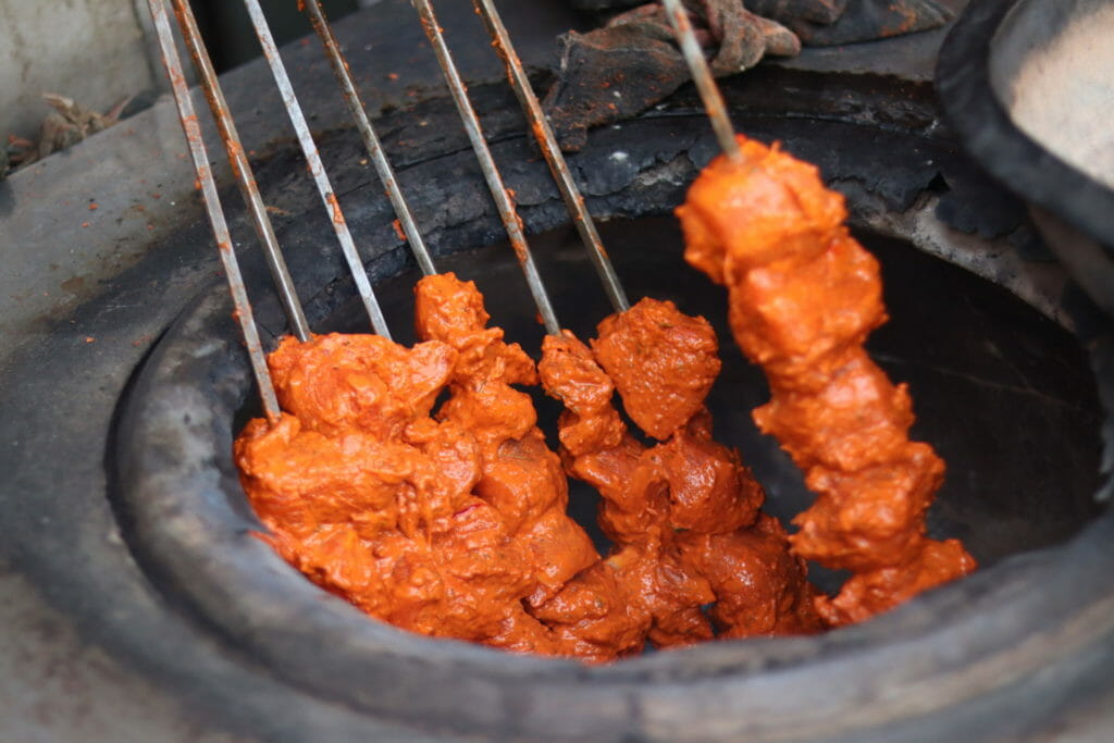 Kebabs being roasted in a coal-powered tandoor at a Delhi restaurant