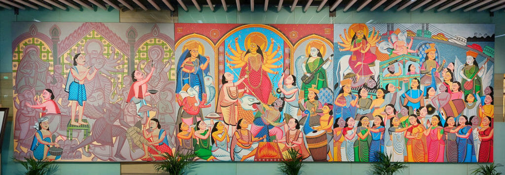 A painting at the Kolkata airport, depicting Durga Puja being performed and celebrated by worshippers