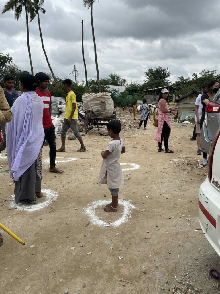 A child stands in the demarcated spots, waiting for relief kits at a relief distribution centre in Whitefield, Bengaluru, after the rains of September 2022 affected the area 