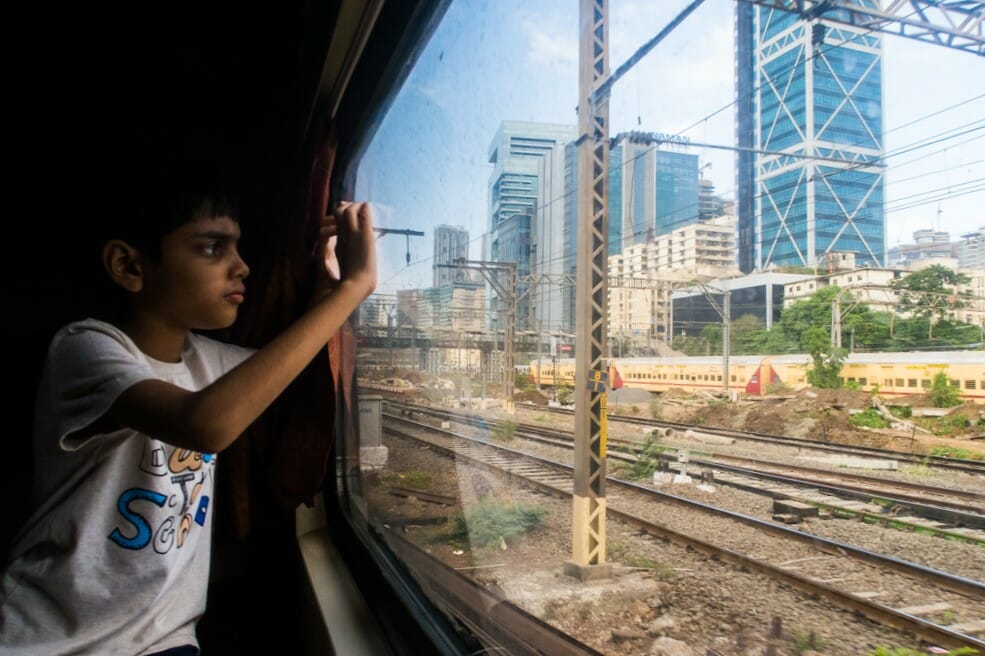 A child looking out of a window from a local AC train in Mumbai