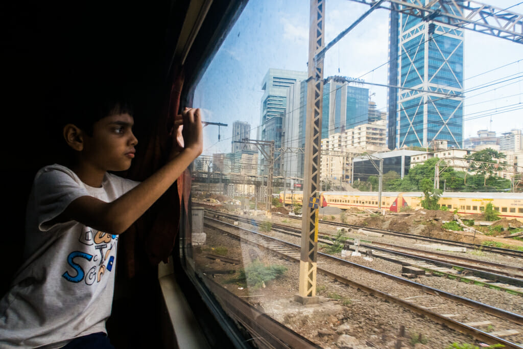 A child looking out of a window from a local AC train in Mumbai