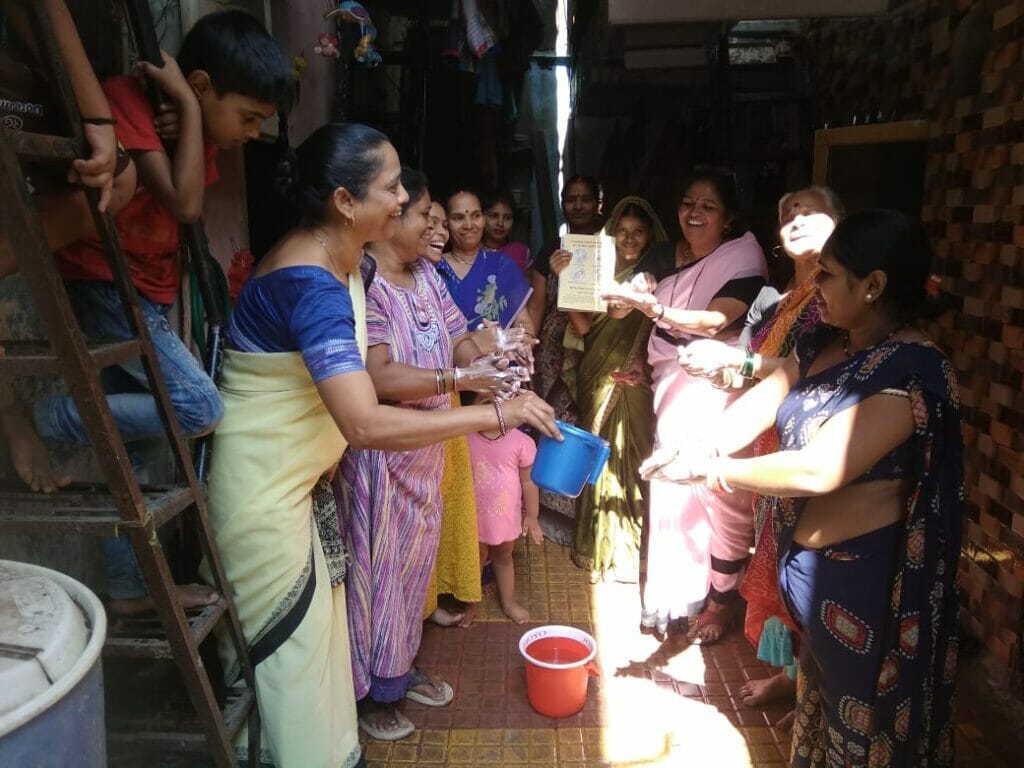 Anganwadi worker and helper conducting door-to-door awareness on hygiene