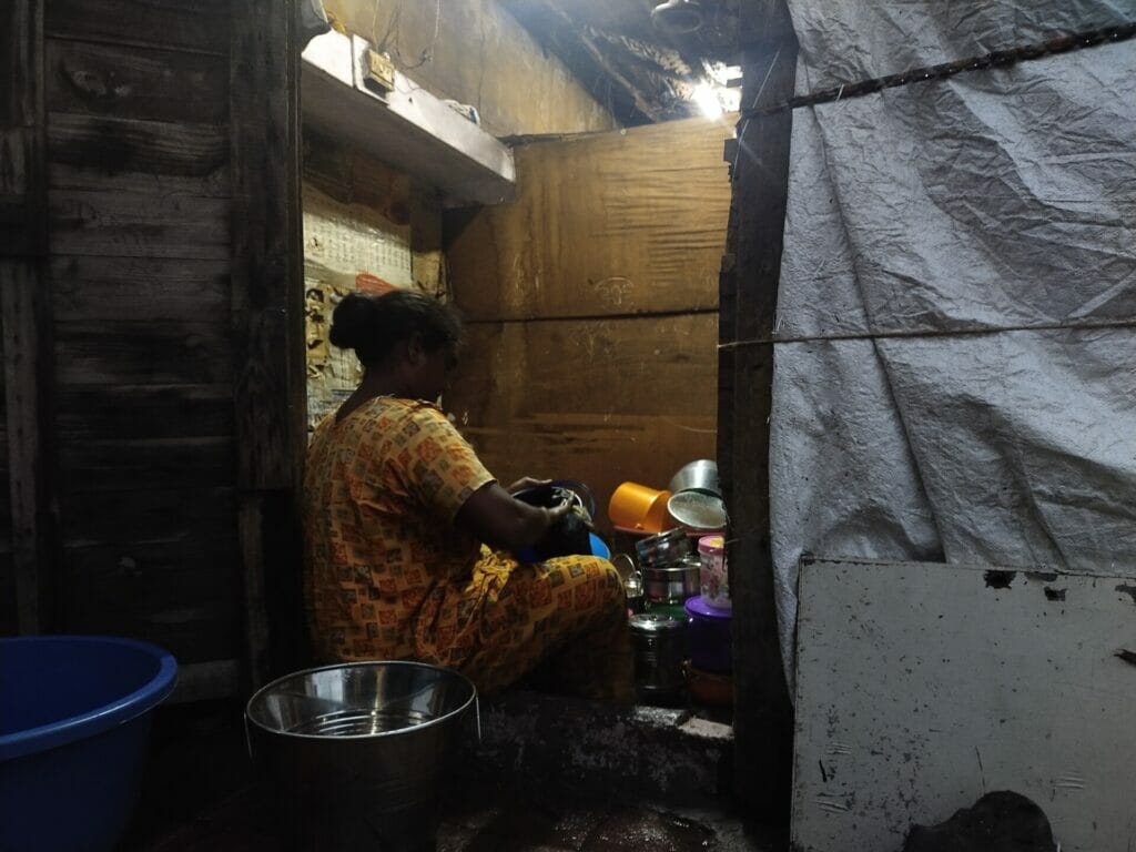 A woman washing vessels inside the house