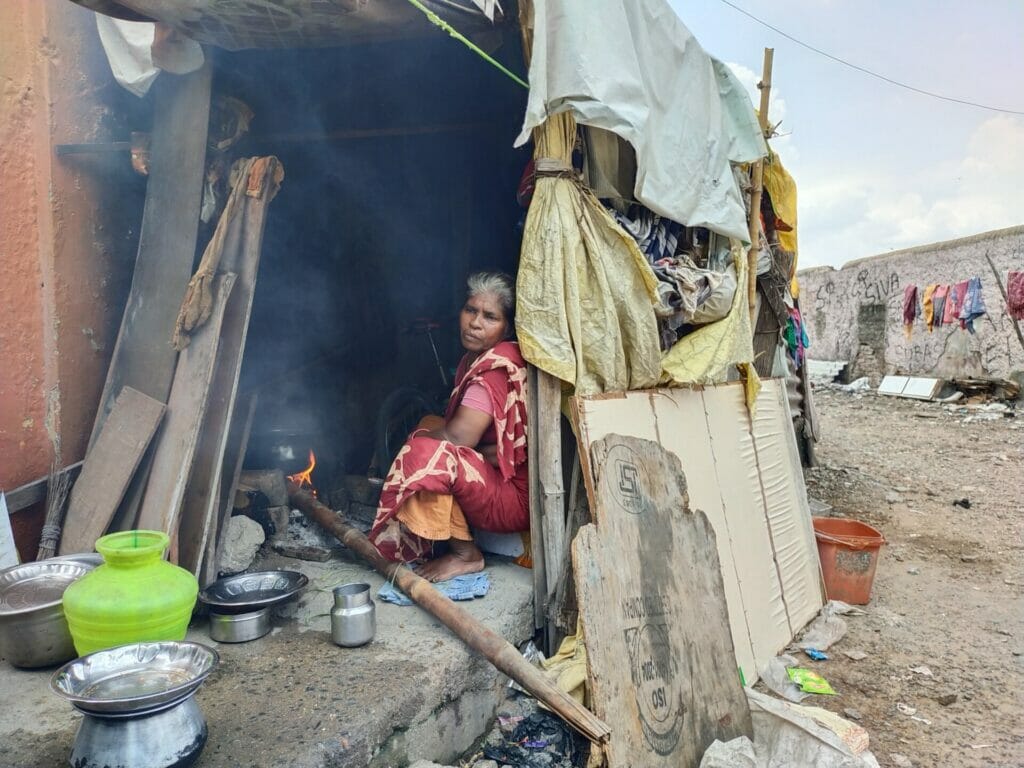 A woman using woods to cook in Thideer Nagar Chennai
