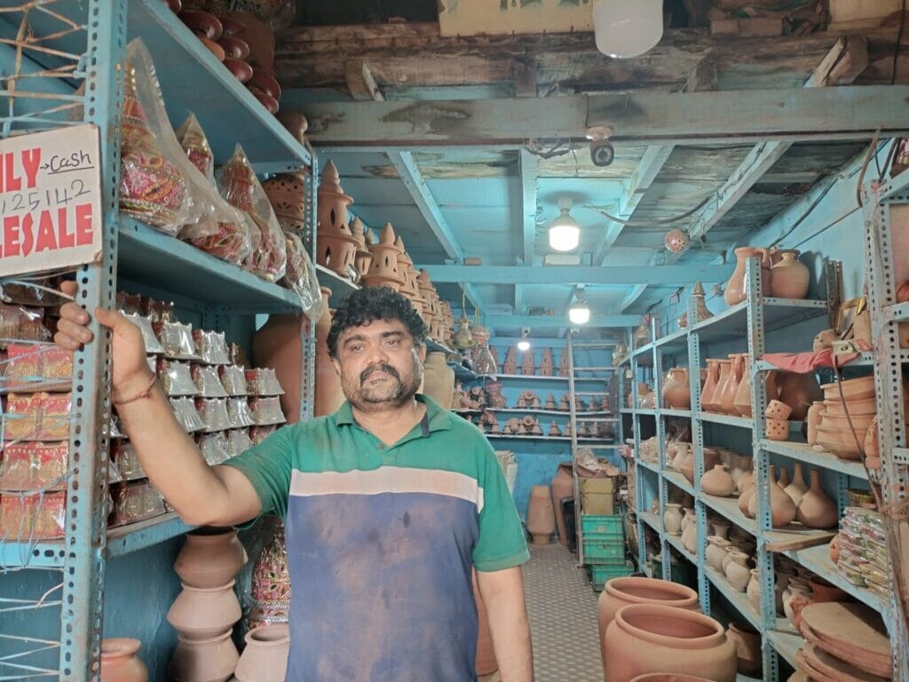 Bharat R tag posing inside his pottery shop.
