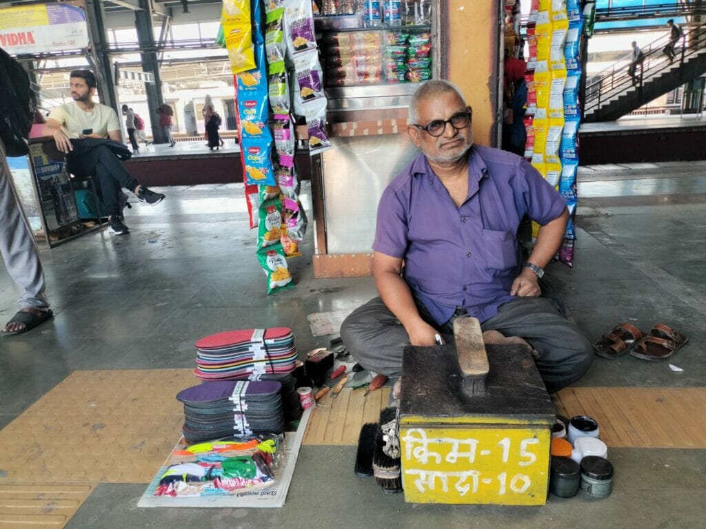 A man sitting behind his shoeshining station 
