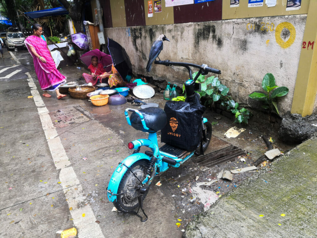 A blue Yulu bike parked at the side of the street