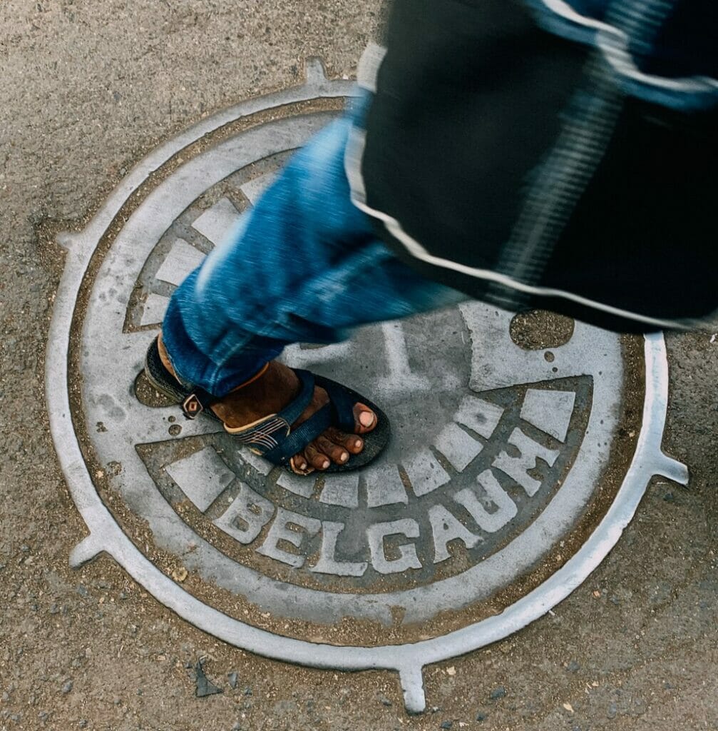 A women stepping on a manhole cover in Mumbai as she walks