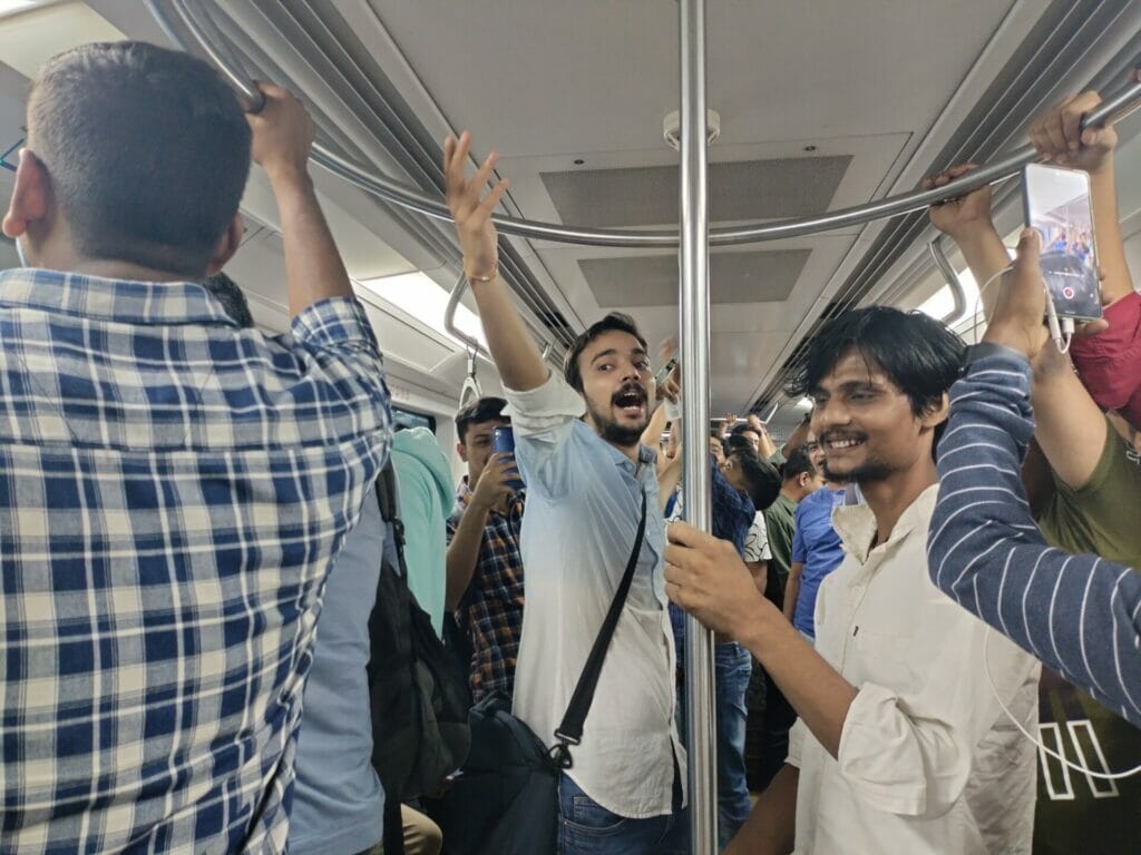 Men in a metro singing as a part of antakshari in the metro