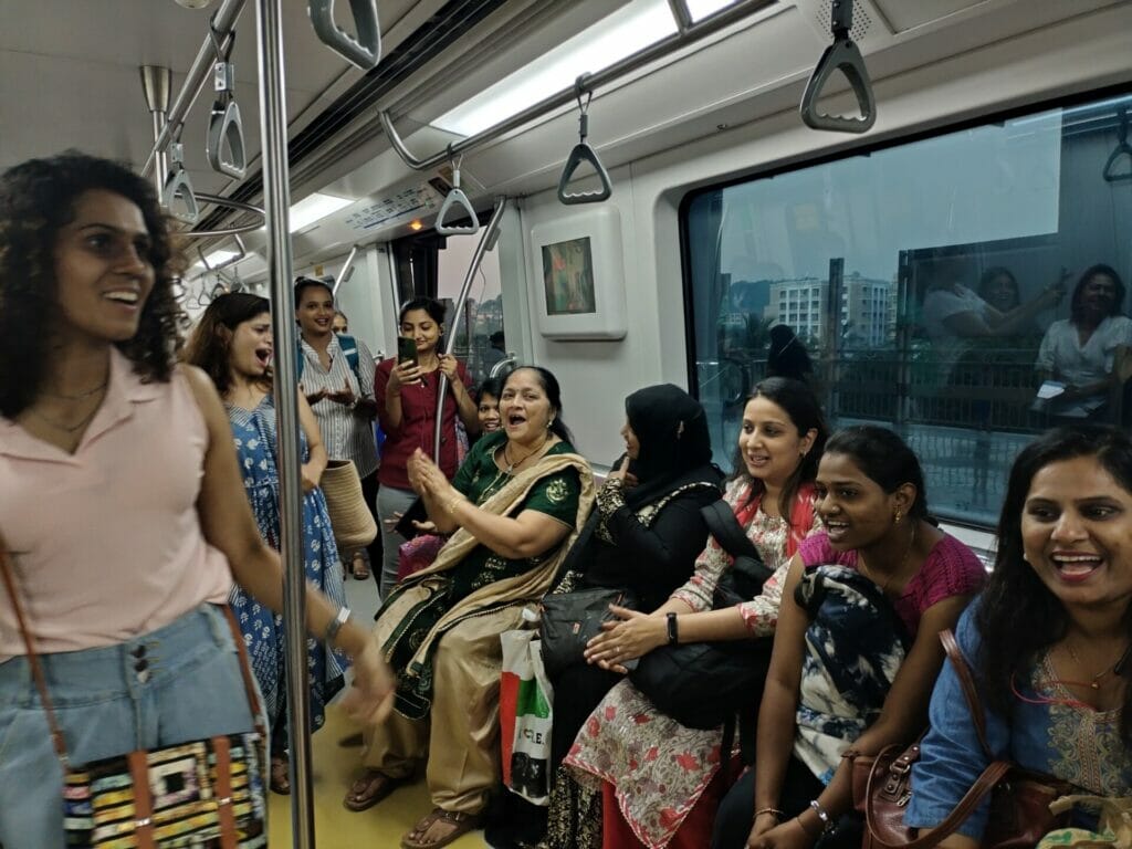 Women sitting on a bench in a metro, one of them clapping