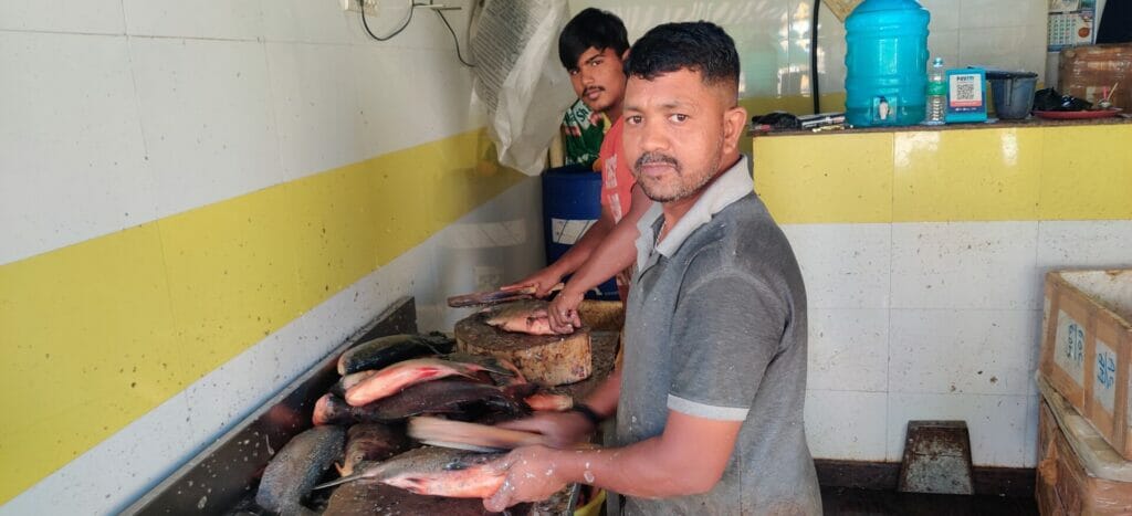 Fish vendors cutting fish. 