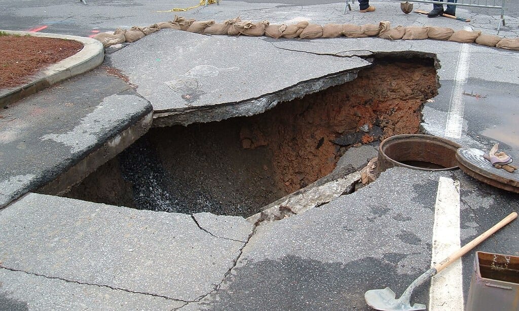 A photo of a sinkhole on a road. 