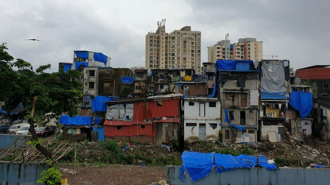 Picture of Mumbai slums, some of the structures have tarpaulins on top of them.