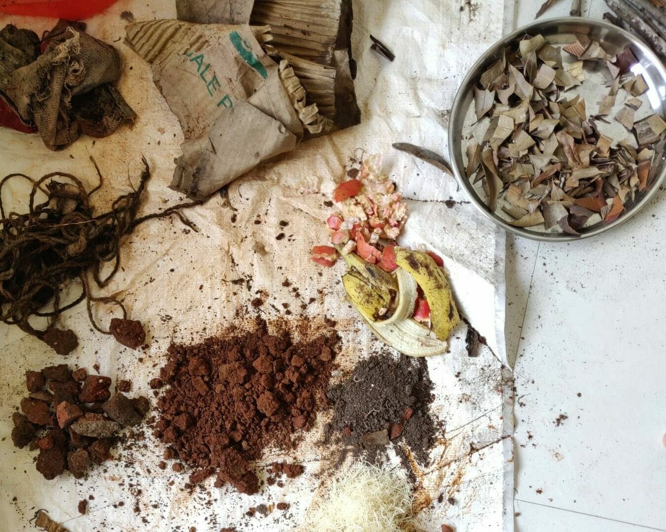 Soil, mud rocks, dries leaves and food waste ready to be mixed for a permaculture garden