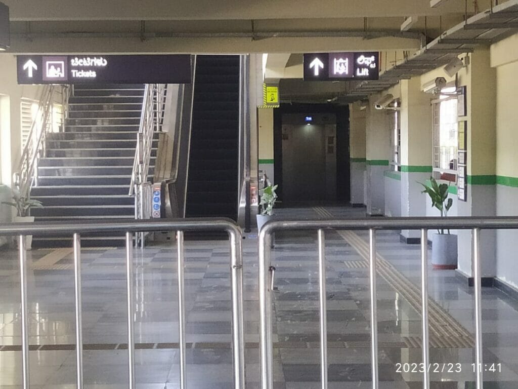 Lift pointing upwards and stairs in Yelachenahalli metro station. 