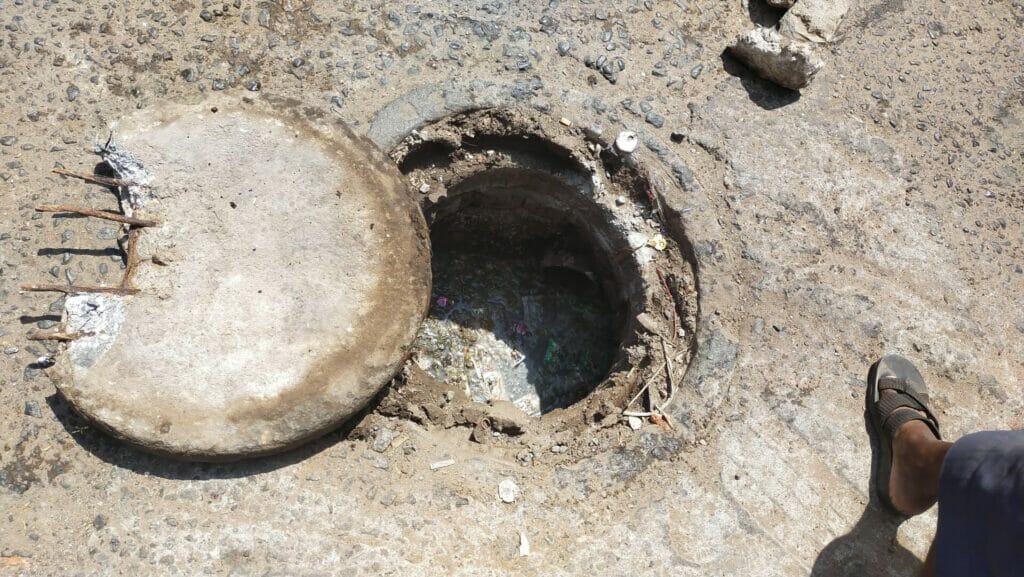 A manhole with a broken cement slab